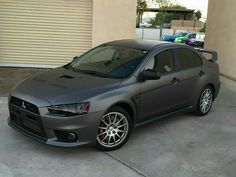 a grey car parked in front of a garage