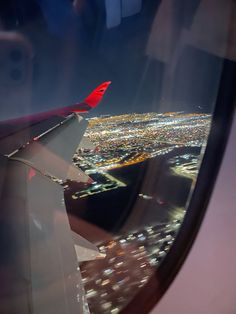 the view from an airplane window shows city lights at night and there is no image on it