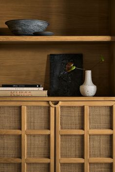 a book shelf with books and a vase on top