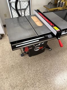 a table sawing machine on the floor in a room