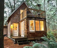 a small cabin in the woods with lights on