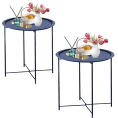 two blue tables with flowers on them and drinks in vases next to each other