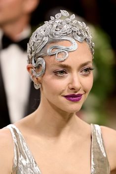 a woman in a silver dress and purple lipstick