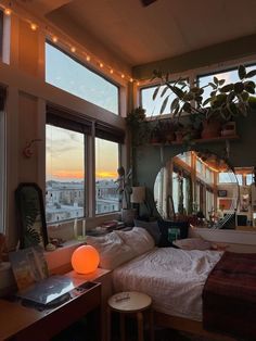 a bedroom with lots of windows and plants in it