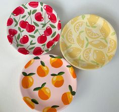 three plates with fruit designs on them are sitting next to each other in the same pattern