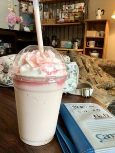 a drink sitting on top of a table next to a book