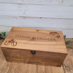 a wooden box with the name mason alexander engraved on it sitting on a wood floor