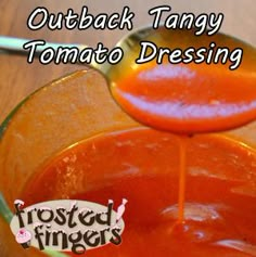 a spoon pouring tomato sauce into a glass bowl with the words, outback tangy tomato dressing