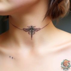 a woman's neck with a tattoo design on the back of her neck and an insect