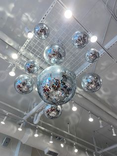 a disco ball chandelier hanging from the ceiling in a room filled with lights