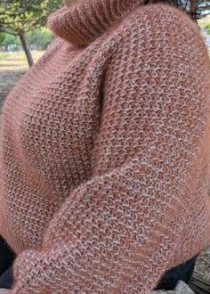 a woman sitting on a bench wearing a pink sweater