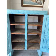 an old blue cabinet with wooden shelves and doors