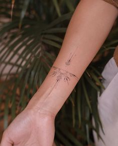 a woman's arm with a bird tattoo on the left side of her wrist