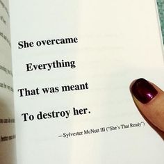 a hand holding an open book with the words she overcome everything that was meant to destroy her