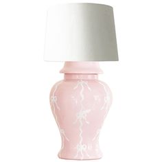 a pink ceramic lamp with a white shade on the top and bottom, against a white background