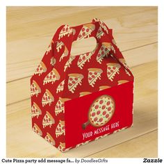 a red box with pizza on it sitting on top of a wooden table next to a wood floor