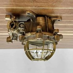 an old light hanging from the ceiling in a room with wood paneling and white walls