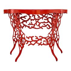 an orange console table with black glass top and coral like design on the bottom, against a white background