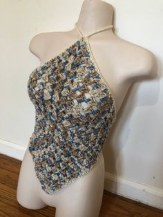 a white mannequin wearing a crocheted top