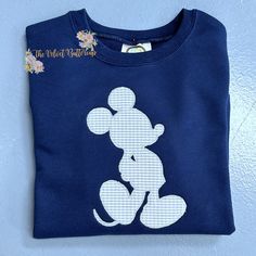 a blue shirt with a white mickey mouse on it