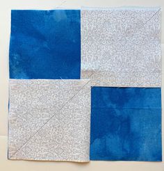 two pieces of blue and white fabric on top of each other with one piece cut out