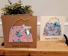 two birthday cards on a table next to a potted plant and a card that says happy birthday