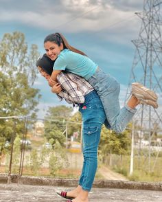 a woman is carrying a man on her back in the middle of an empty lot