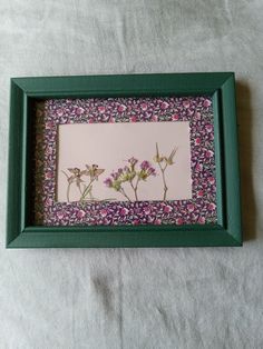 a green frame with some flowers on it