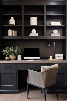 a desk with a chair, computer and bookshelf