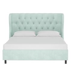 an upholstered bed with white sheets and light green headboard, on a white background