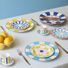 the table is set with plates, bowls and utensils