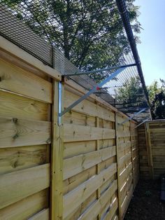 a wooden fence that is next to a tree