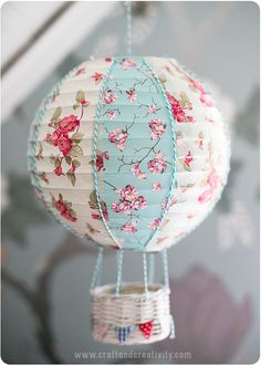 an ornament shaped like a hot air balloon is hanging from a string with flowers on it