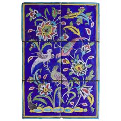 a blue tile with flowers and birds painted on the tiles, all in different colors