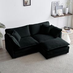 a black sectional sofa sitting on top of a white rug