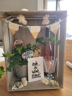 a wooden box filled with wine bottles and flowers next to a sign that says go on vine o'clock