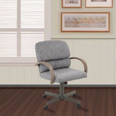 an office chair sitting on top of a hard wood floor next to a window with blinds