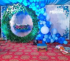 blue balloons and greenery decorate the backdrop for an event