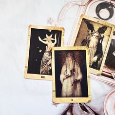 three tarot cards with pictures of women and animals in them on a white table cloth