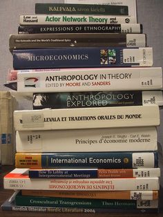 a stack of books sitting on top of a wooden table