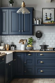 a kitchen with blue cabinets and white tile backsplashes, wood floors and wooden flooring