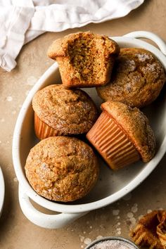 several muffins in a white bowl on a table