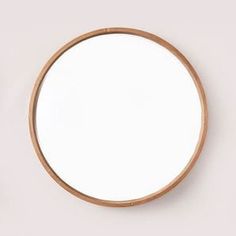 a round mirror sitting on top of a white wall