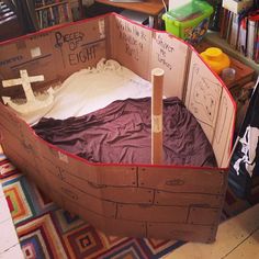 a cardboard boat made to look like it is floating in the water with an anchor on top