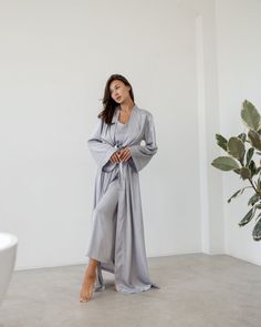 An elegant robe made of Armani silk fabric is presented in a maxi length. The model is styled with long wide sleeves and a belt. The robe emphasizes the figure well and goes well with a nightgown. Available in the following sizes: 42-46 and 48-52 Sizes: This PJ is available in sizes S-M, L-XL Body Measurements: Size  S - M:  Bust measurement - 45-48 cm,   Hips - 51 сm (stretches),  Robe length - 140 cm,  Sleeve length - 53 cm Size  L - XL:  Bust measurement - 50-54 cm,   Hips - 57 сm (stretches),  Robe length - 142 cm,  Sleeve length - 53 cm Colors: Black, White, Gray Materials:  All PJ sets are made of comfortable Armani silk. It's a breathable and allergy-friendly material. Great in terms of thermoregulation.  Fabric content:  Armani silk (50% silk, 45% viscose, 5% elastane) Breathable W Elegant Sleep Maxi Dress, Elegant Long Sleeve Sleepwear Set, Elegant Silk Floor-length Robe, Elegant Floor-length Silk Robe, Elegant Maxi-length Kimono For Loungewear, Elegant Maxi Length Kimono For Loungewear, Elegant Loungewear Kimono Maxi Length, Elegant Long Sleeve Silk Abaya, Elegant Silk Abaya With Long Sleeves