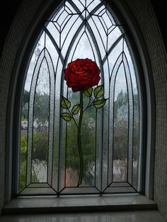 a stained glass window with a red rose in it