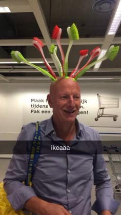 a man is smiling while wearing toothbrushes on top of his head in an airport