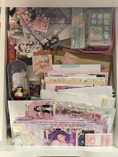 an open drawer filled with lots of different types of cards and magnets on top of it