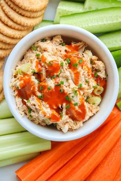 a white bowl filled with coleslaw and carrots next to crackers