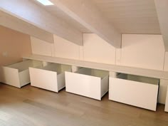 an empty room with several white cabinets and drawers on the floor in front of it